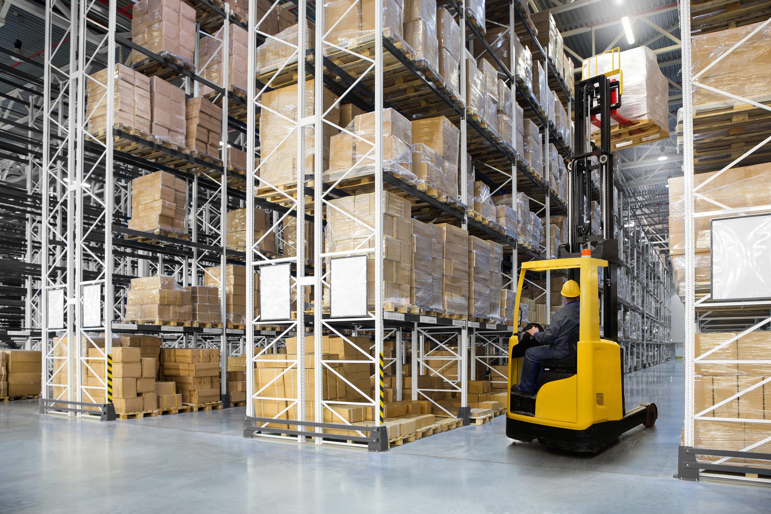 Huge distribution warehouse with high shelves and forklift with