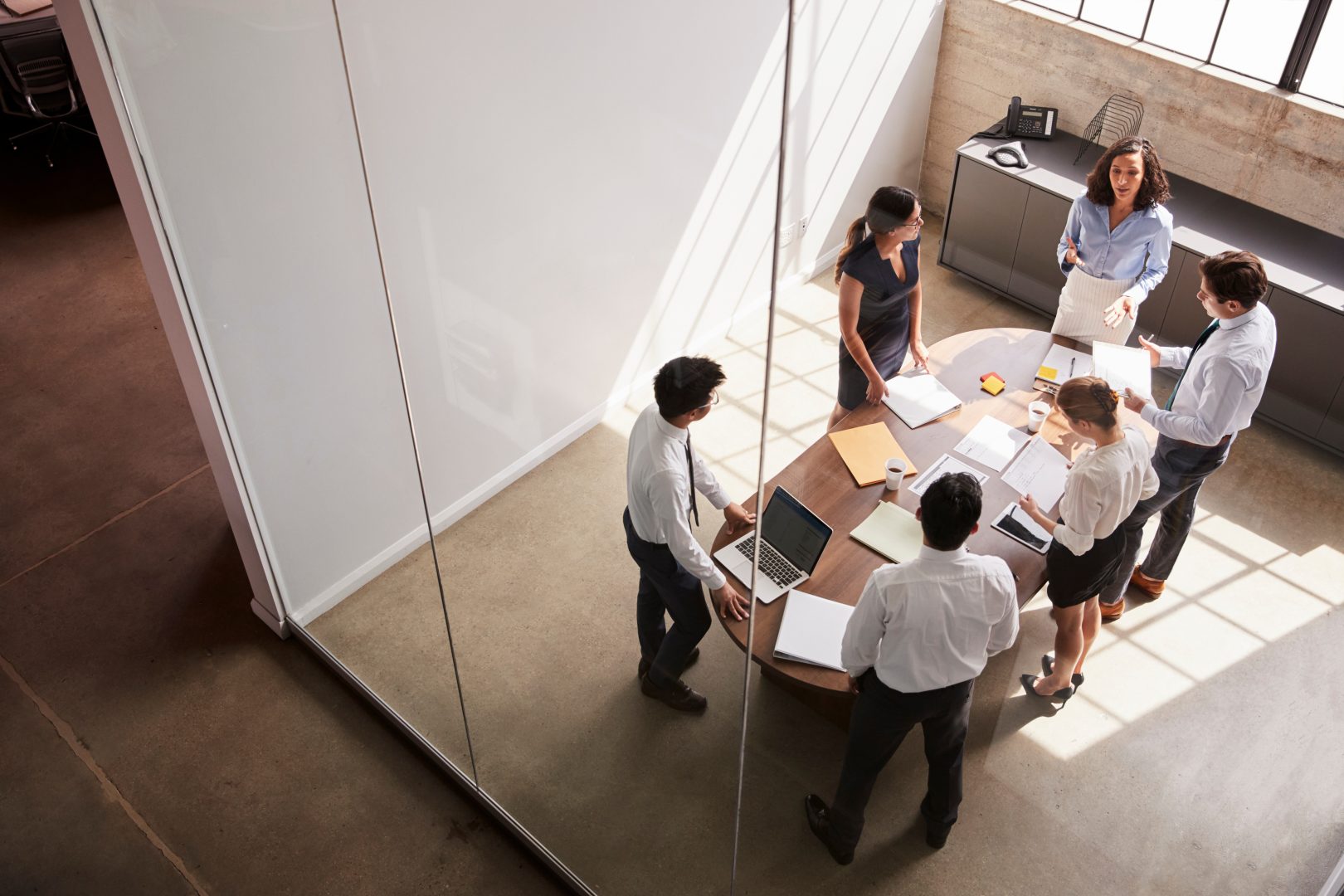 Female manager in team meeting, elevated view through window