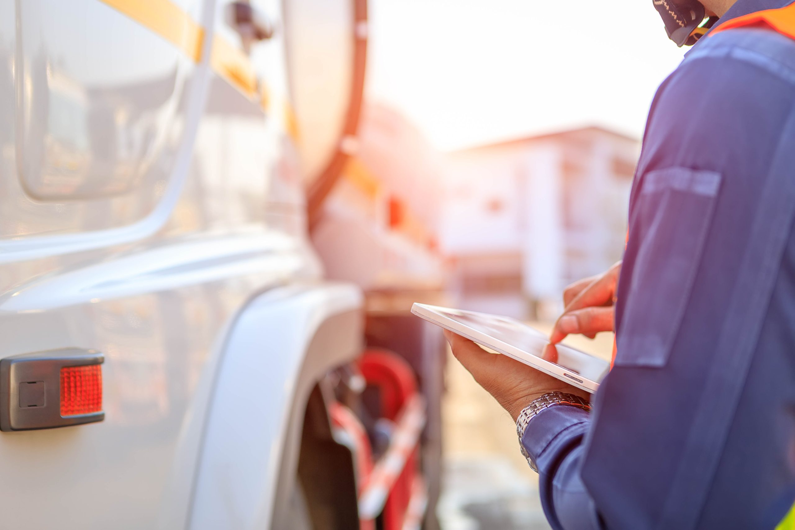 Truck drivers hand holding tablet checking the product list,Driver writing electronic log books,spot focus.