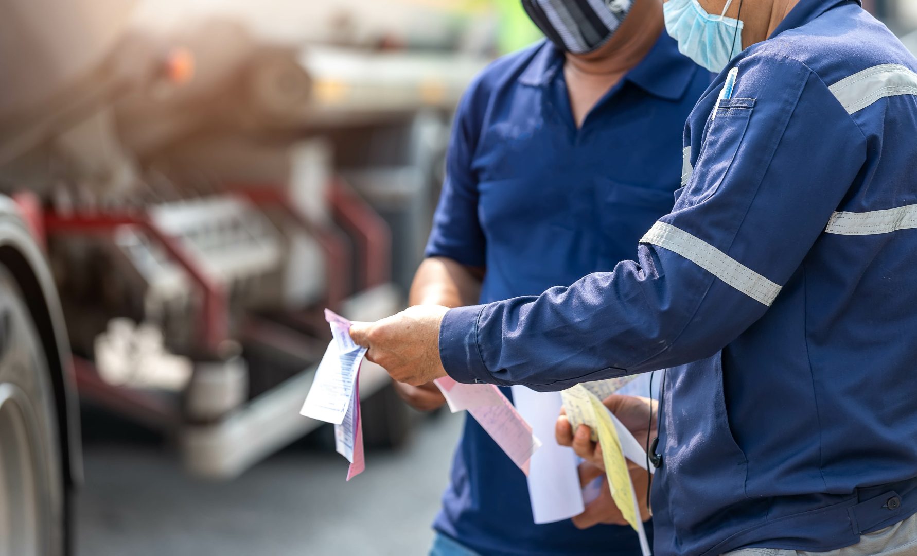 Truck drivers hand holding clipboard Check the product list, Preforming a pre-trip inspection on a truck, spot focus.