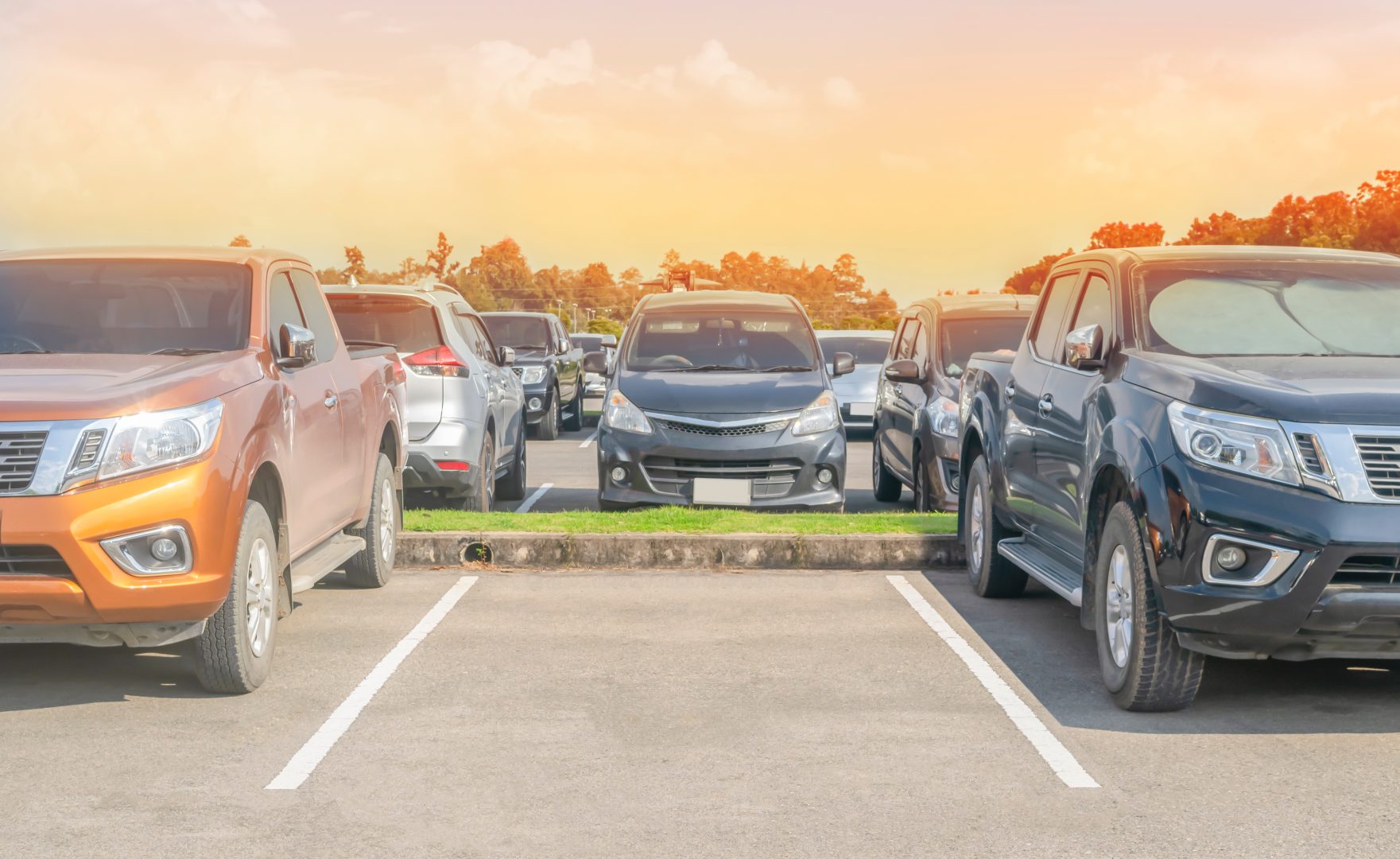 Car parked in asphalt parking lot and one empty space parking  in nature with trees, beautiful cloudy sky and mountain background .Outdoor parking lot with fresh ozone and green environment