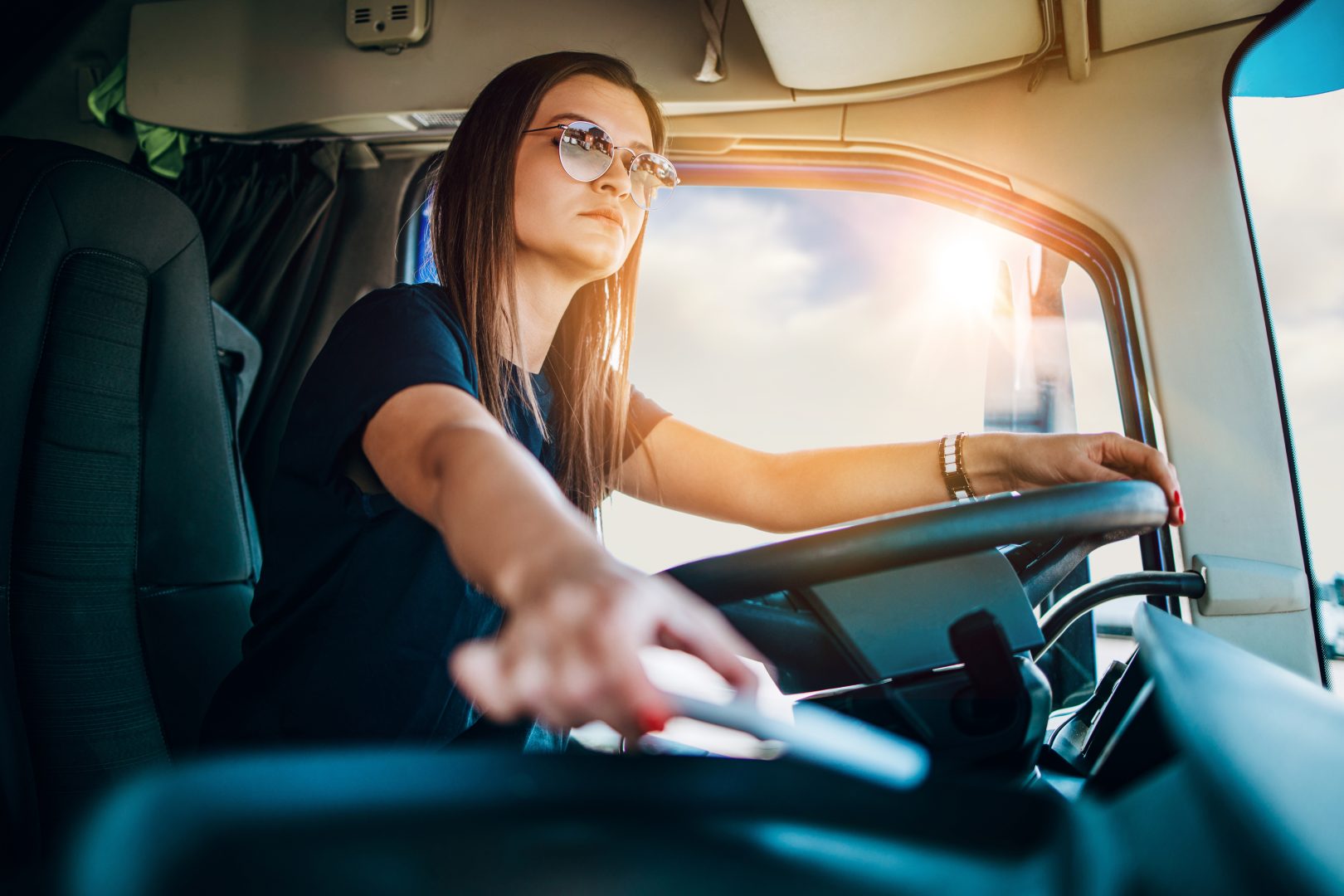 Portrait of beautiful young woman professional truck driver sitt