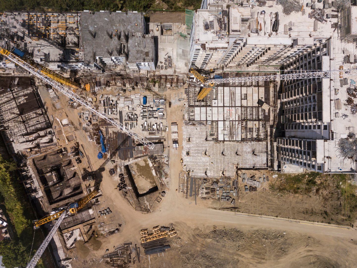 Aerial of a construction site, midrise residential condominiums constructed with prefab concrete. Several tower cranes erected onsite.