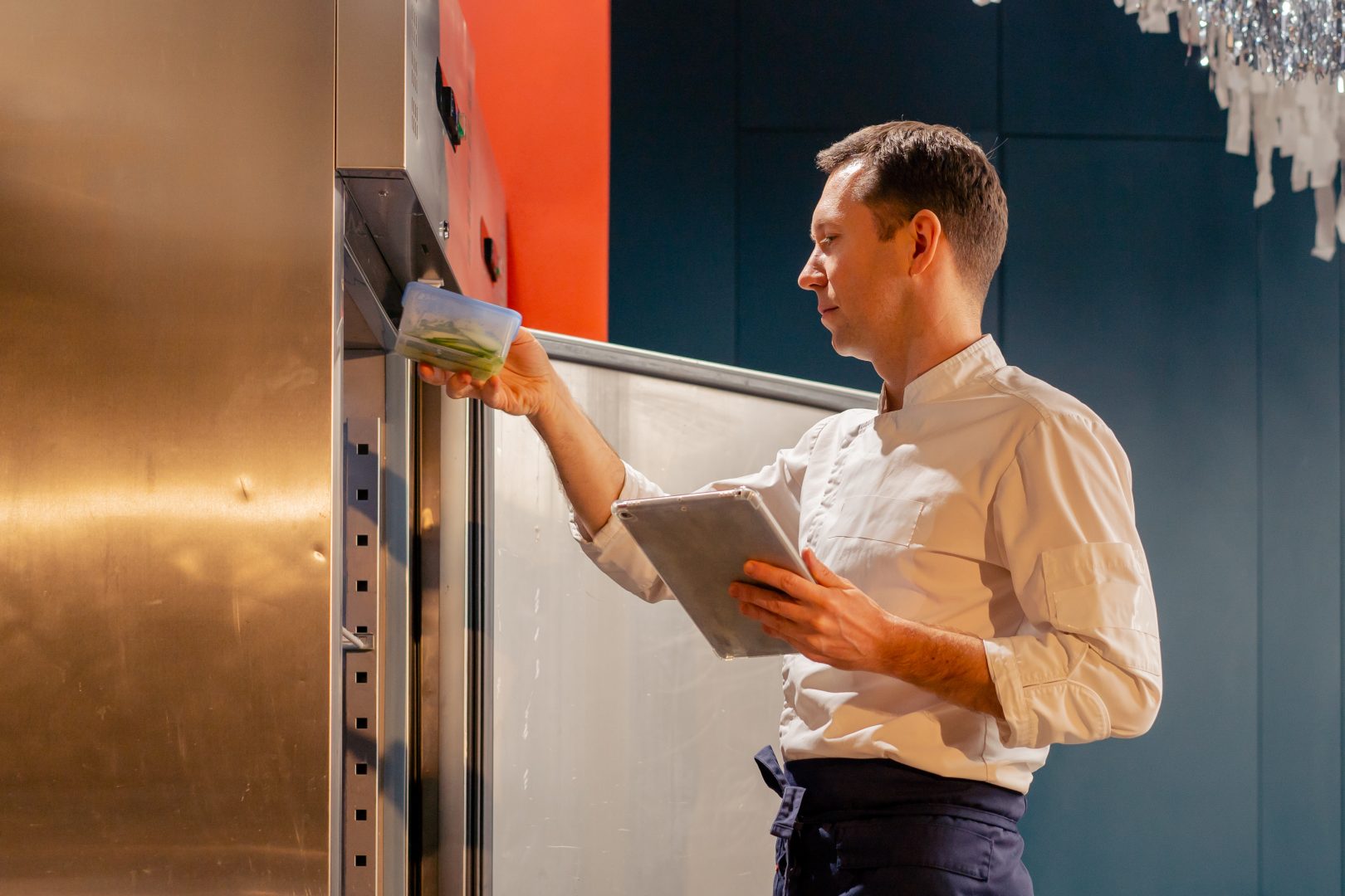 professional kitchen chef looks into the fridge and chooses ingredients for cooking food concept