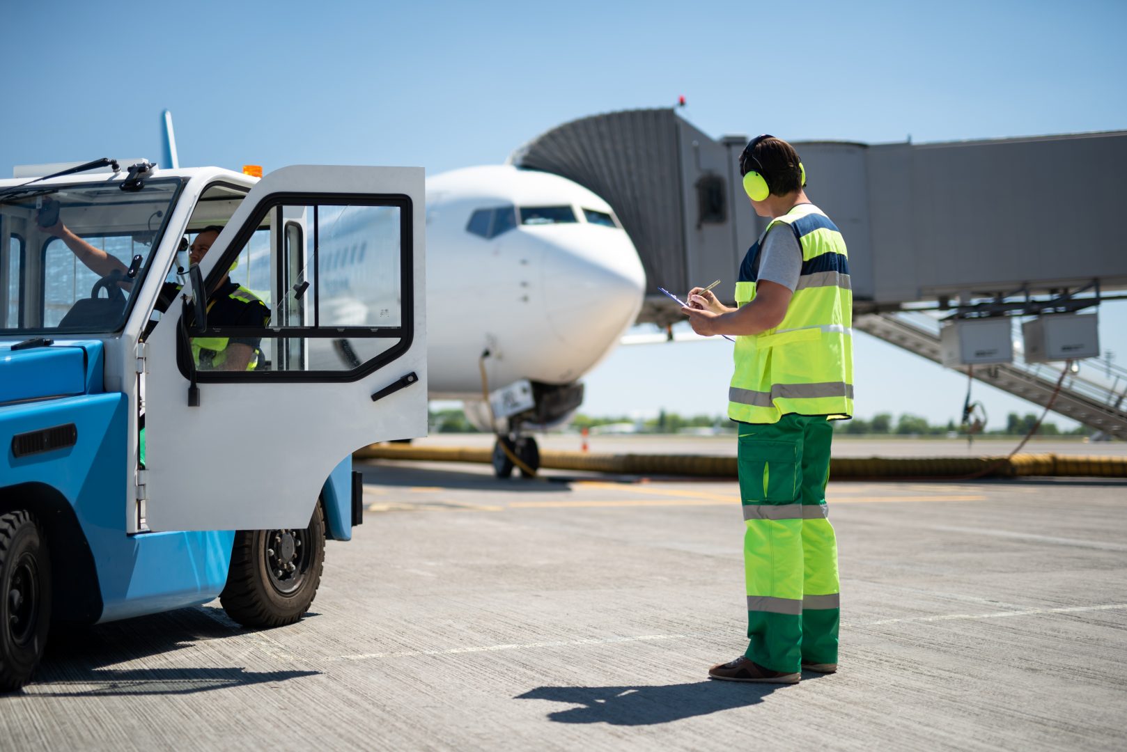 Male worker controlling airplane while colleague sitting in the car