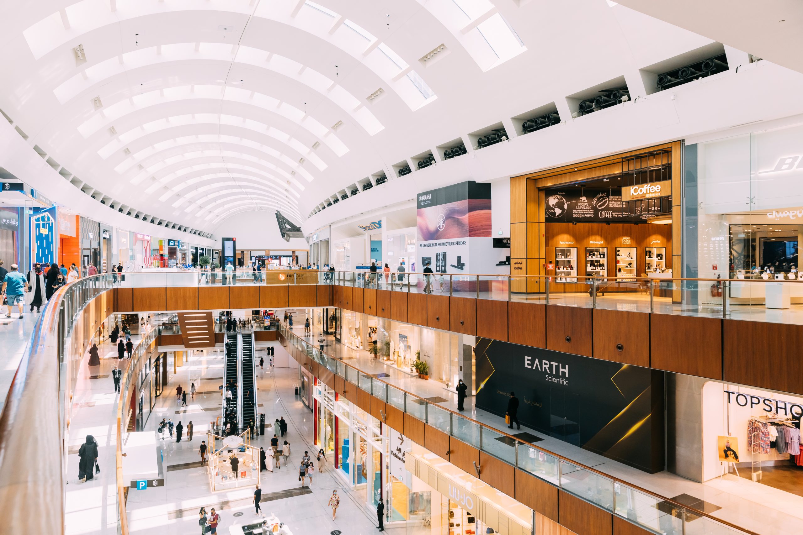 Dubai, UAE, United Arab Emirates – May 28, 2021: People visiting Dubai shopping mall. People going shopping in shopping center indoor. People resting at modern Dubai shopping mall centre