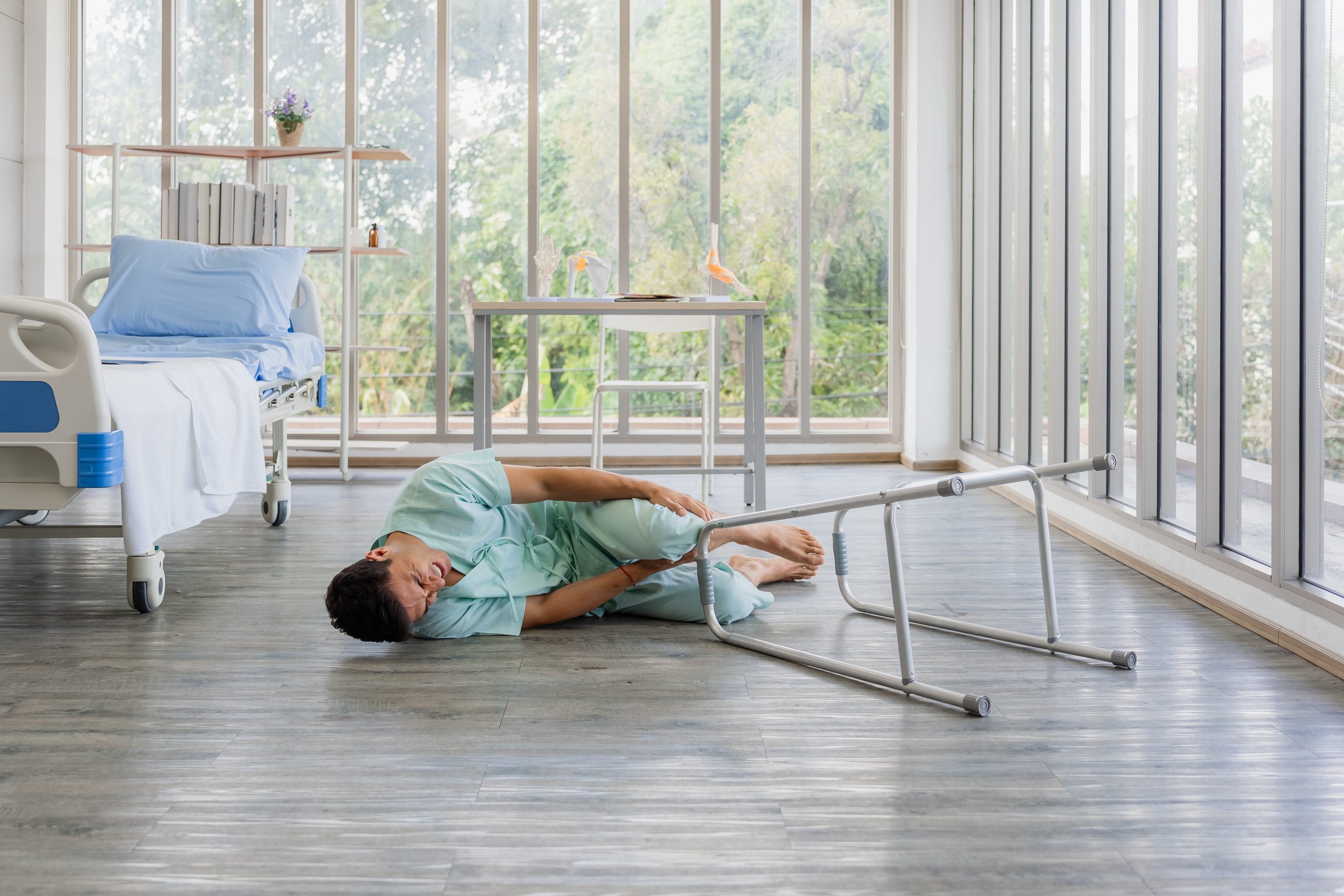 The patient journey begins with an accident, a man falls and is later seen in a wheelchair consulting with his doctor. A disabled man in a wheelchair looking out a hospital window, contemplating his recovery with a doctor’s support.